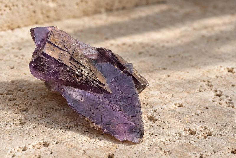Natural purple fluorite gemstone crystal with layered cubic cleavage and violet tones