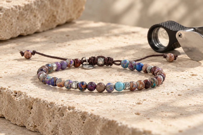 Men’s purple gemstone bead bracelet displayed on warm travertine stone