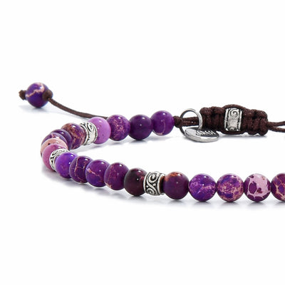Close-up of a purple jasper stone bracelet with silver spacers and adjustable brown cord.