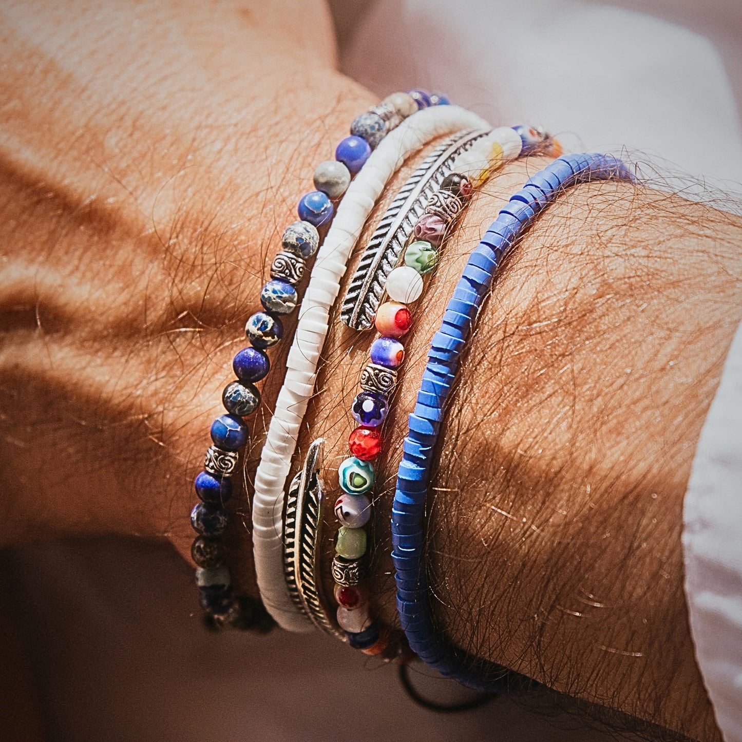 Santorini bracelet set on wrist in natural light, showing blue disc beads and colorful patterns