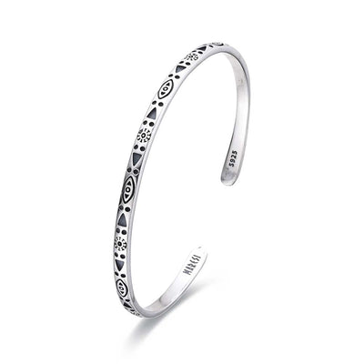 Close-up of sterling silver men's bracelet with symbolic design and polished finish