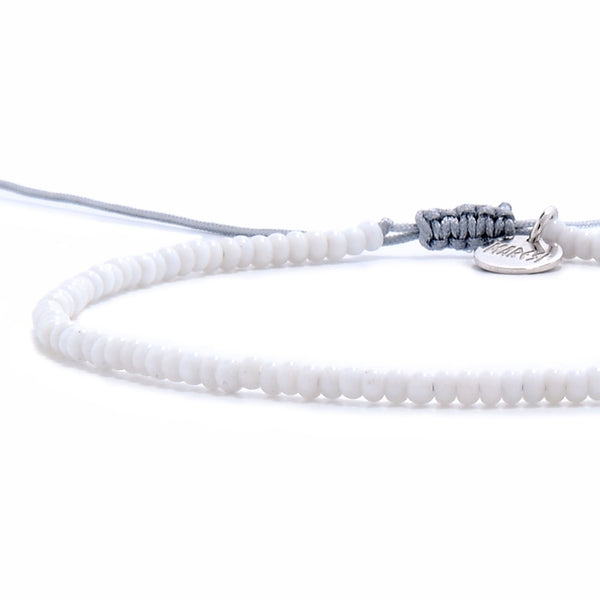 Small beaded bracelets in white with gray cord side view