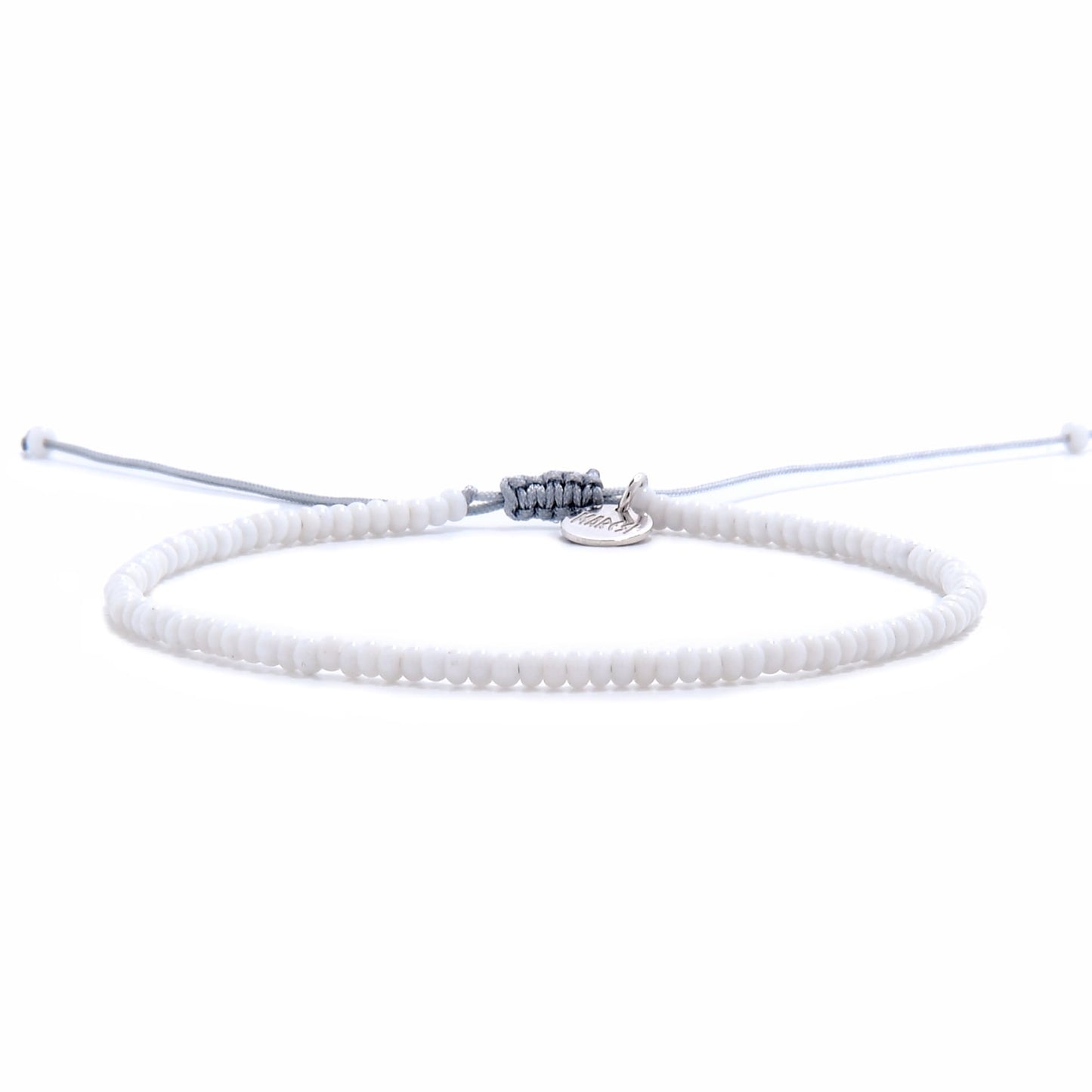 Front view of small beaded bracelet featuring uniform white seed beads and an adjustable drawstring closure