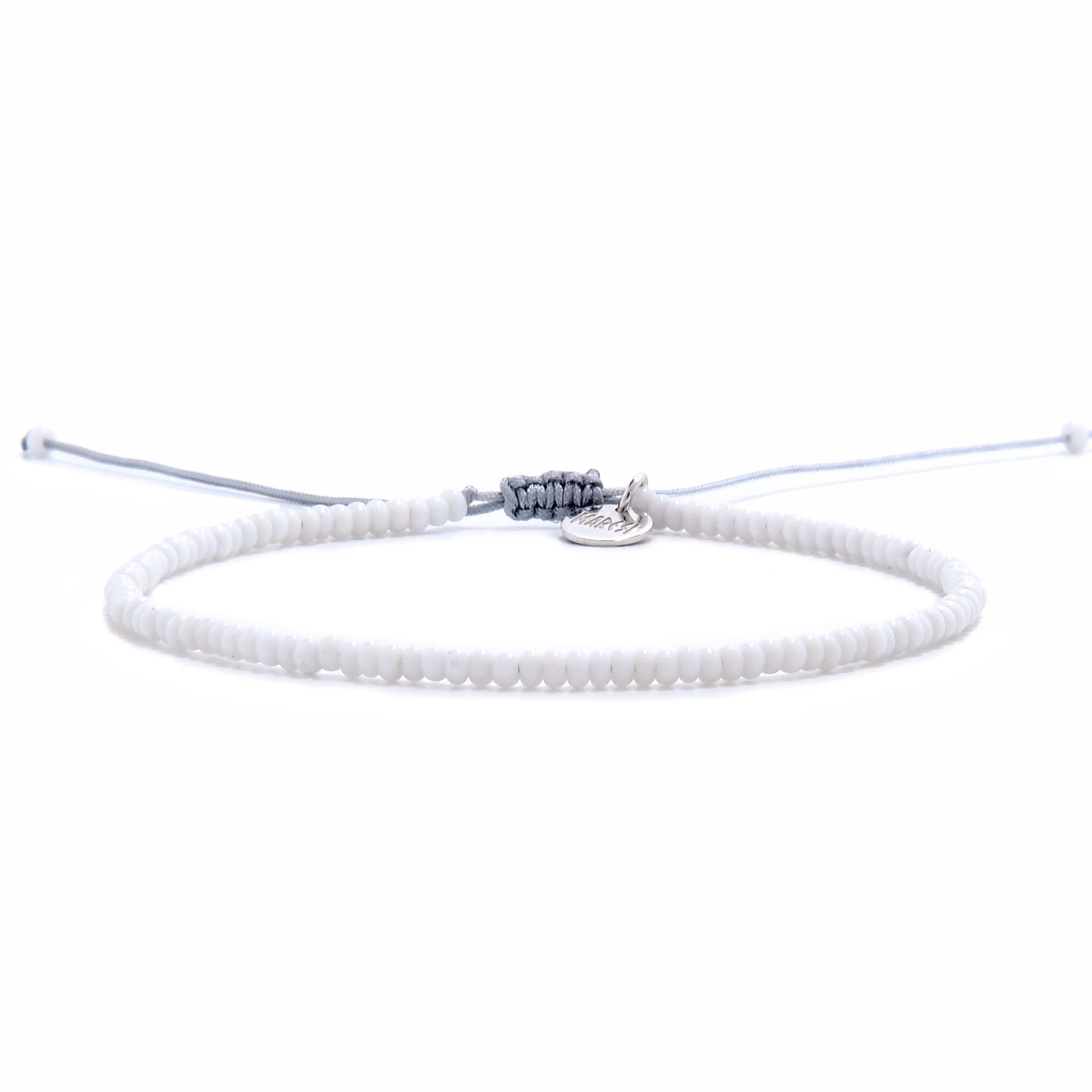 Front view of small beaded bracelet featuring uniform white seed beads and an adjustable drawstring closure