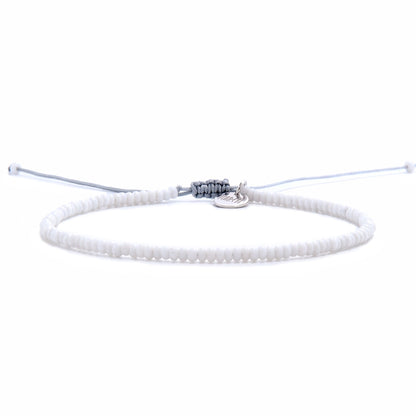 Front view of small beaded bracelet featuring uniform white seed beads and an adjustable drawstring closure