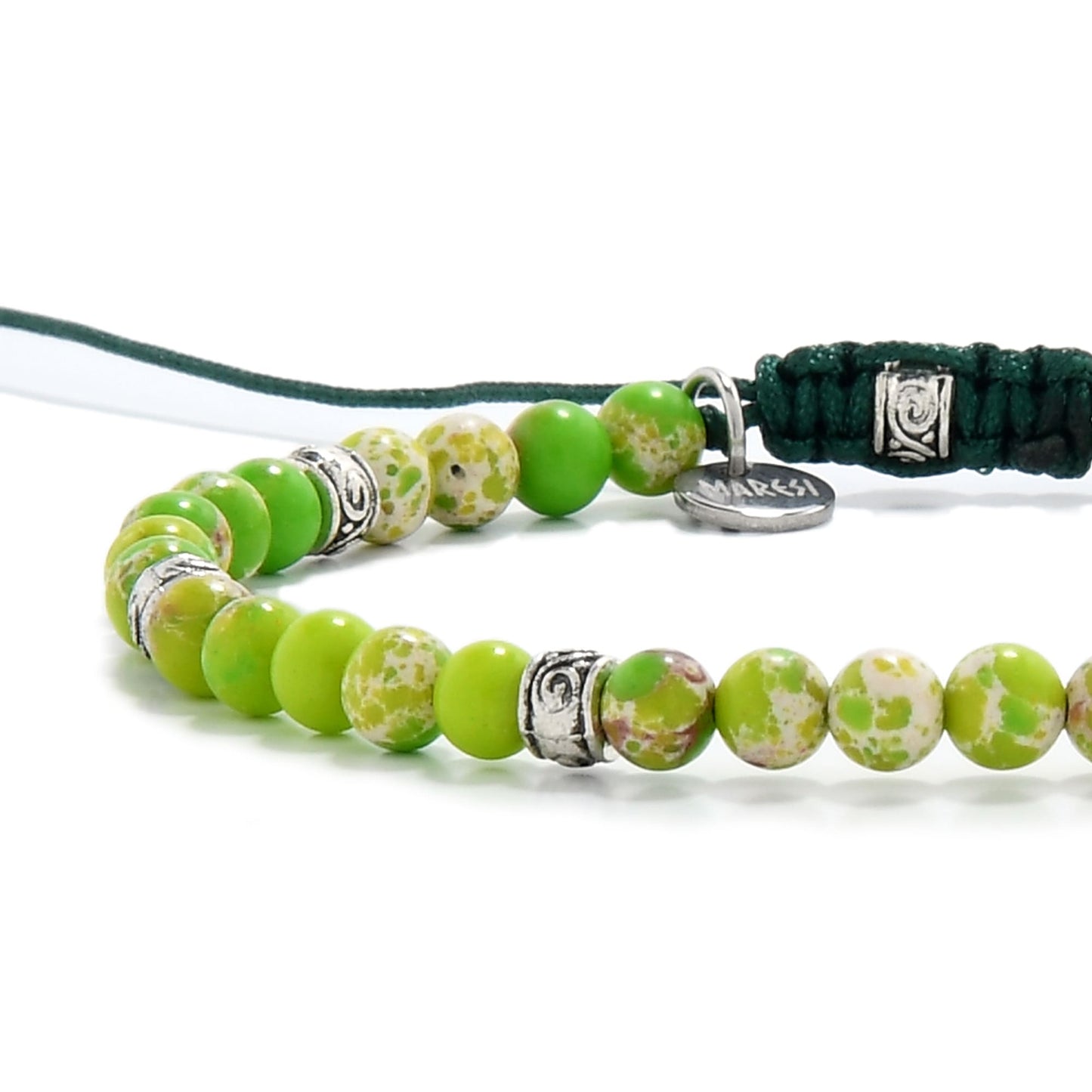 Macro view of polished green jasper stones featuring earthy patterns and metal detailing