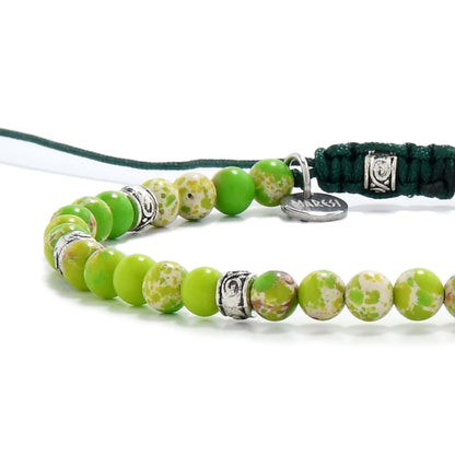 Macro view of polished green jasper stones featuring earthy patterns and metal detailing