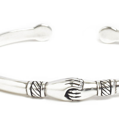 Close-up of stainless steel bracelets featuring handshake detail.