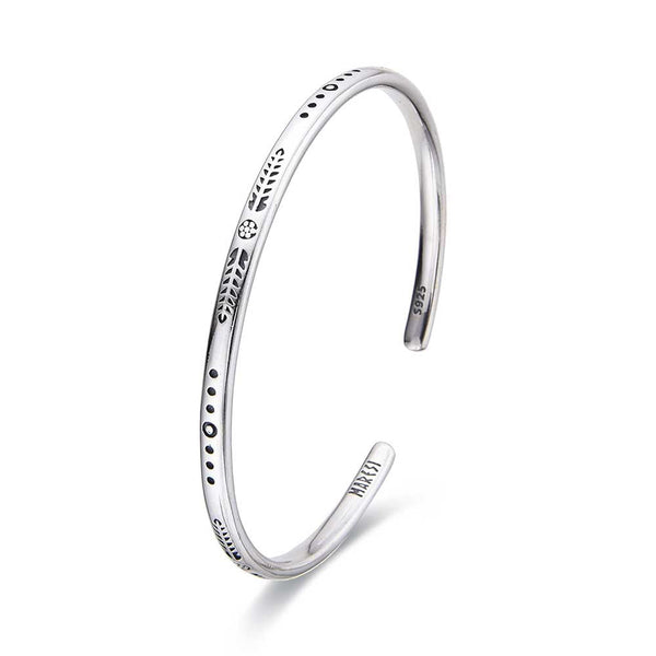 Sterling silver bracelet bangle with minimalist engraved pattern in studio view.