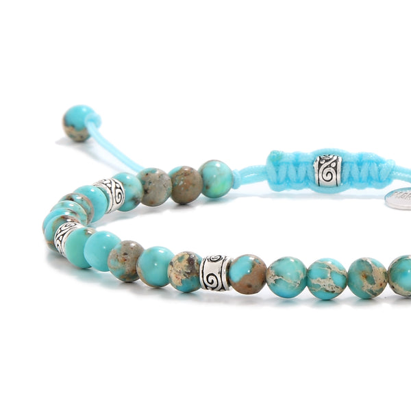 Turquoise jewelry close-up showing sea sediment jasper beads with detailed silver elements.