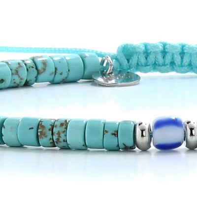 Close-up of turquoise men’s bracelets with round beads and a blue accent bead on a braided cord.