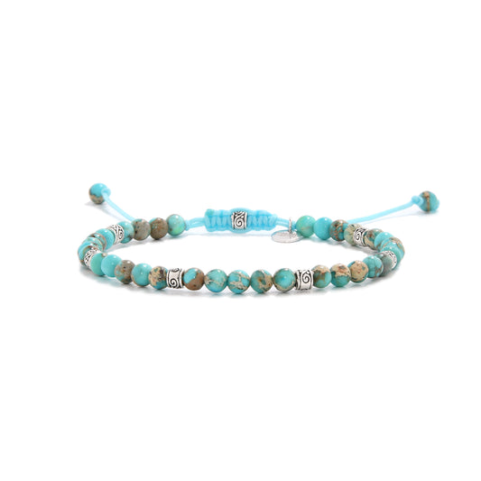 Turquoise jewelry featuring sea sediment jasper beads and silver spacers on a light blue cord.