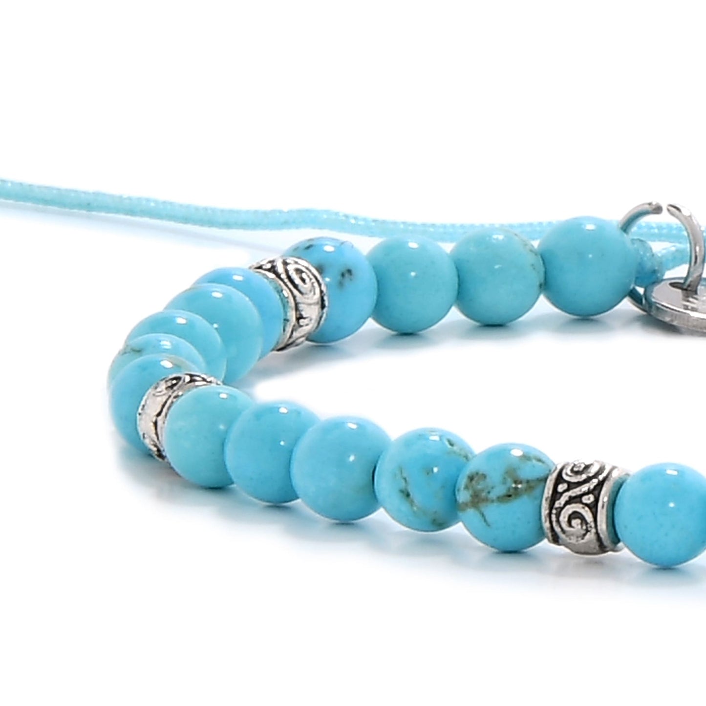 Zoomed view of turquoise gemstone beads with engraved silver elements on bracelet
