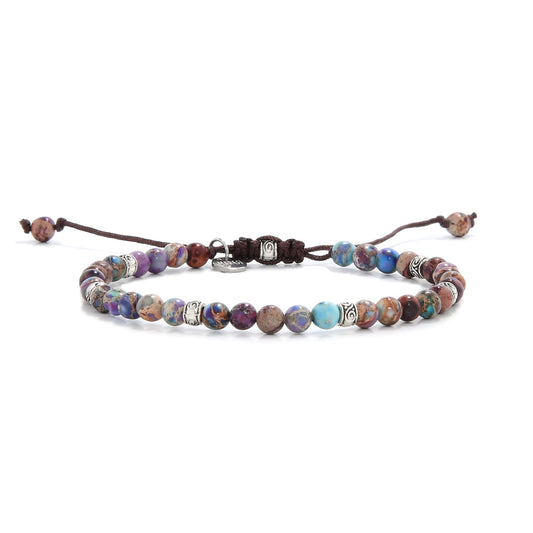 Sea sediment jasper bracelet with multicolored beads and silver accents on white background