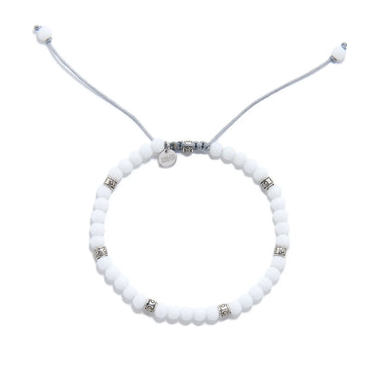 Top view of White Jade Bracelet for men with white beads, silver spacers, gray cord, and charm.