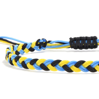 Close-up of zig zag friendship bracelet with braided yellow, black, and blue threads