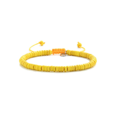Handmade yellow bracelet with adjustable tie, laid flat on white background