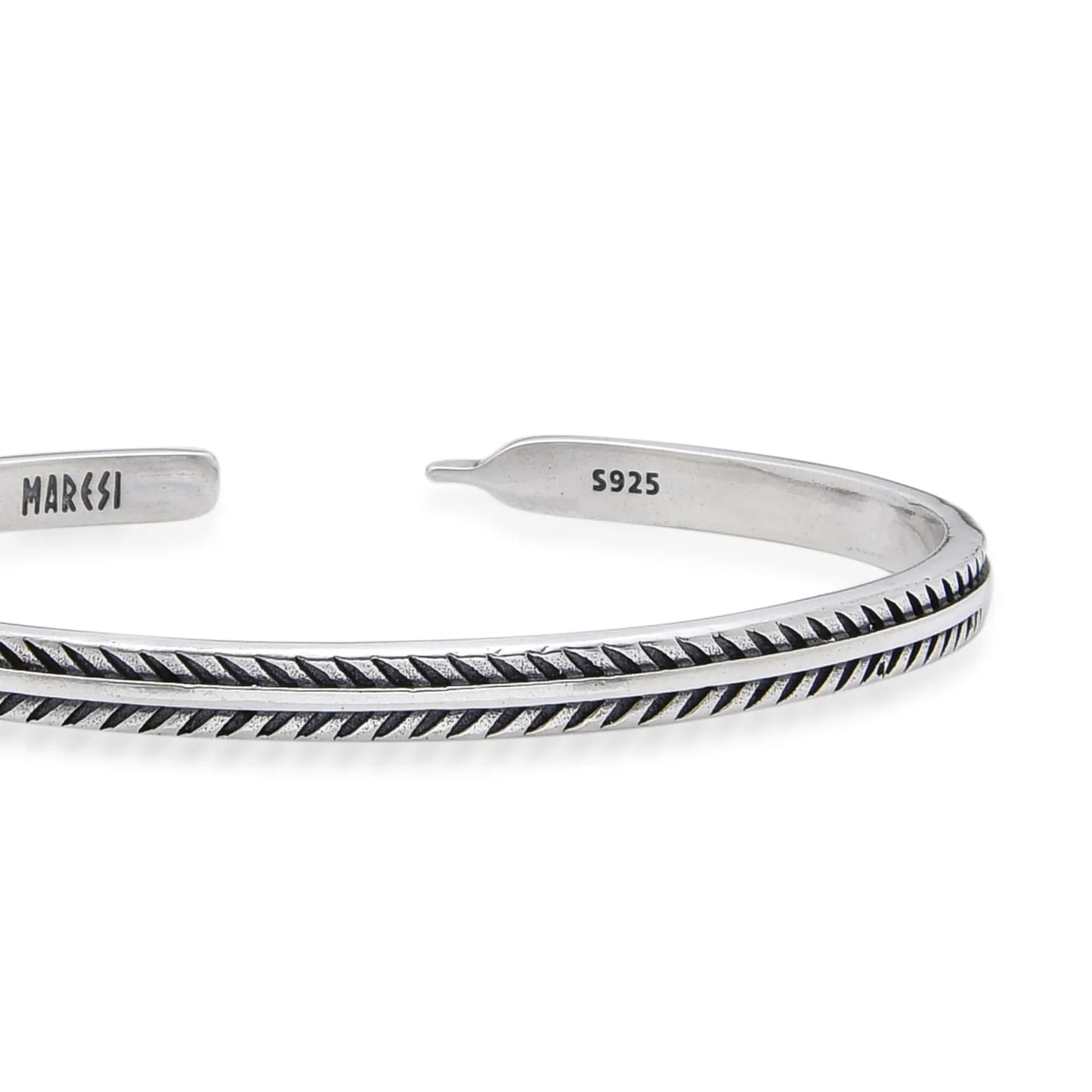 Close-up of Bangles Bracelets with feather-style engraving, polished edges, and stamped inner end