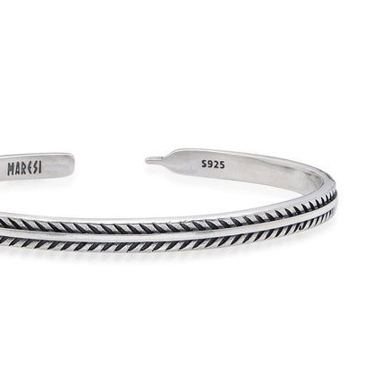 Close-up of Bangles Bracelets with feather-style engraving, polished edges, and stamped inner end