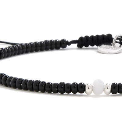 Detailed view of Bead Bracelet Black with black seed beads with white accent beads, seed bead texture, and cord knot
