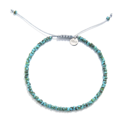 Bead Bracelet shown from above with turquoise Picasso seed beads with gray cord and round bracelet shape