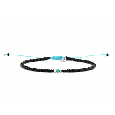 Beaded Bracelet shown in full view with black seed beads with turquoise accent beads and adjustable cord