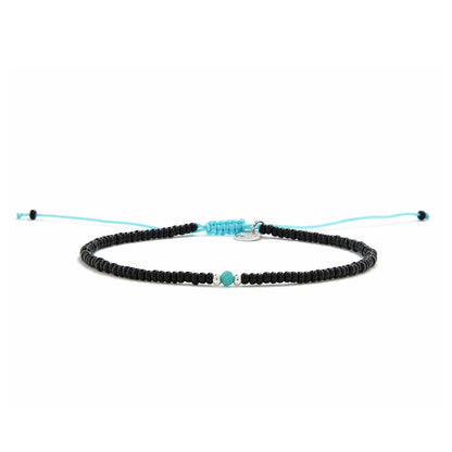 Beaded Bracelet shown in full view with black seed beads with turquoise accent beads and adjustable cord