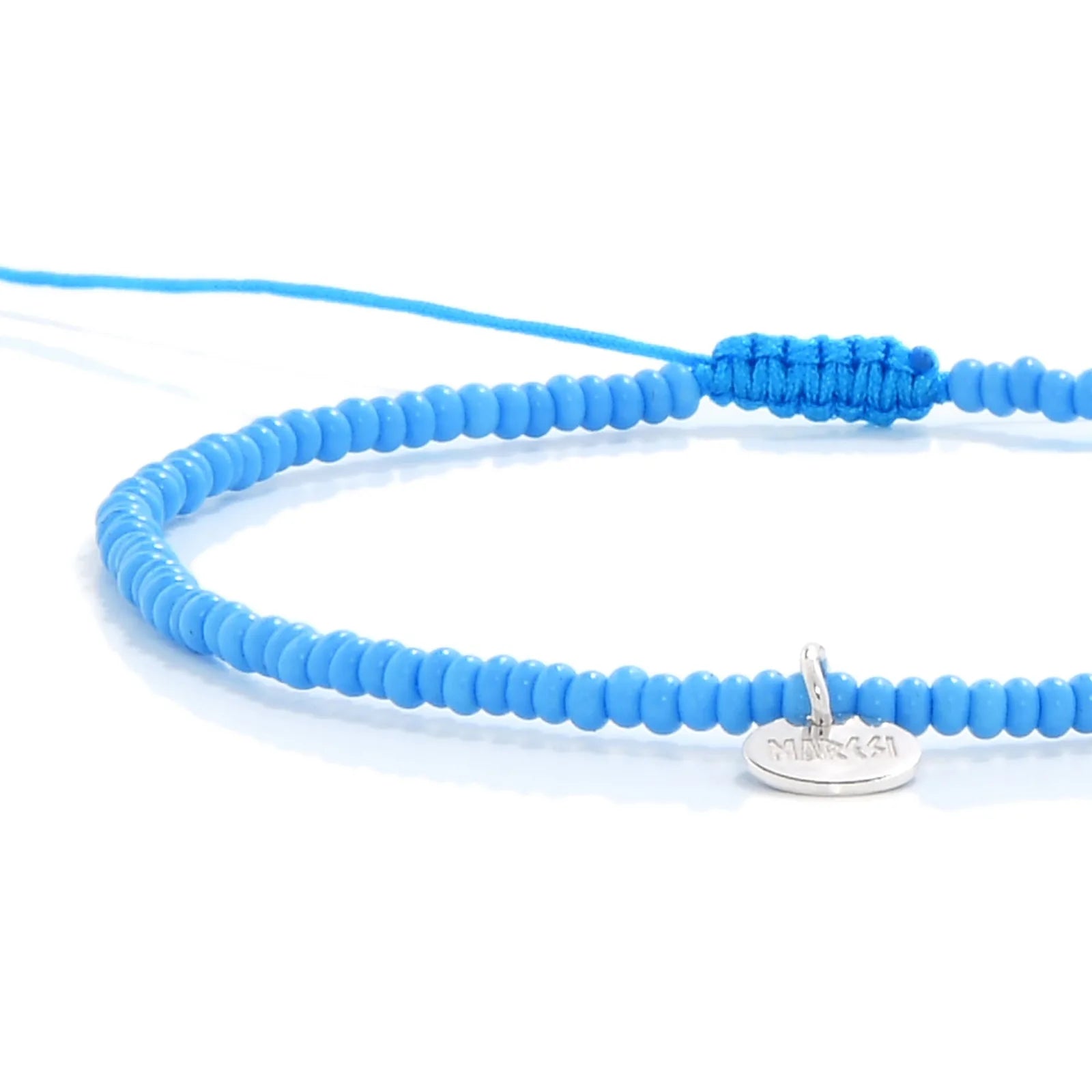 Close-up of Beaded Cross Bracelet showing turquoise seed beads with silver cross charm, silver charm, and cord closure