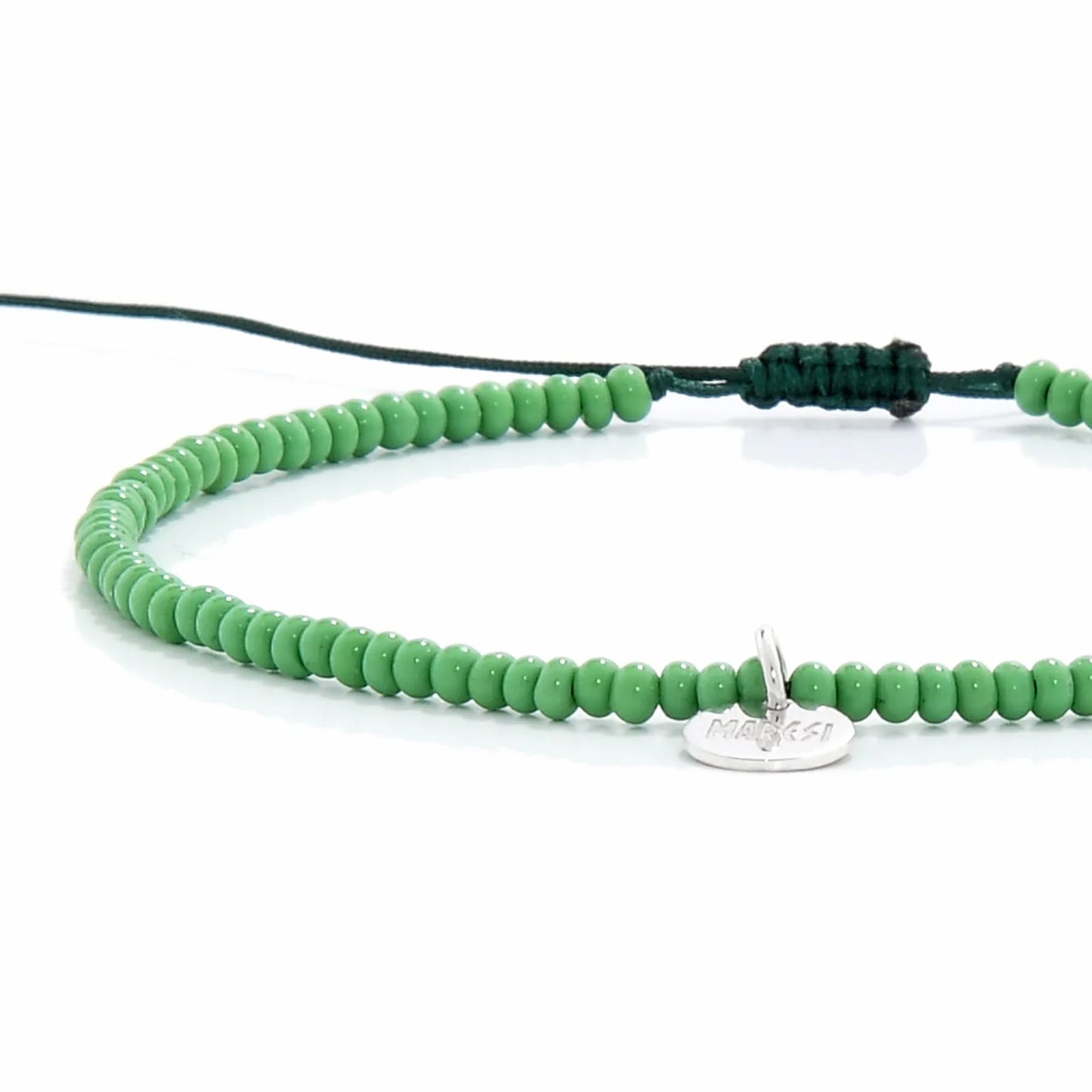 Close-up of Beaded Stretch Bracelets showing green seed beads with dark green cord, silver charm, and cord closure
