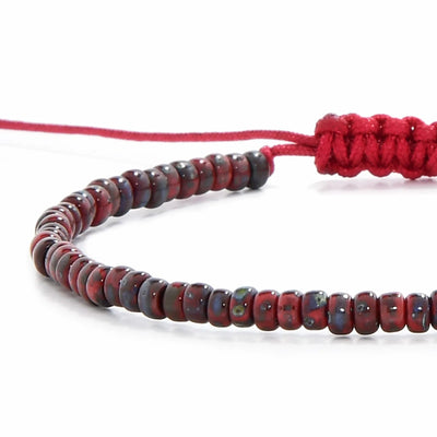 Detailed view of Beads Bracelets with red Picasso seed beads with red cord, Picasso seed bead texture, and cord knot
