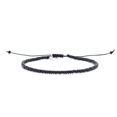 Black Bead Bracelet shown in full view with black seed beads with silver charm and adjustable cord