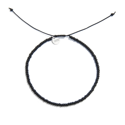 Black Bead Bracelet shown from above with black seed beads with silver charm and round bracelet shape