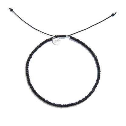 Black Bead Bracelet shown from above with black seed beads with silver charm and round bracelet shape