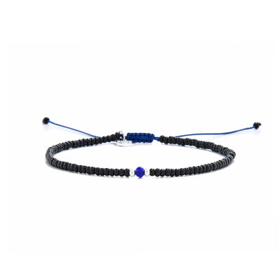 black and blue bead bracelet shown in full view with black seed beads with blue accent beads and adjustable cord