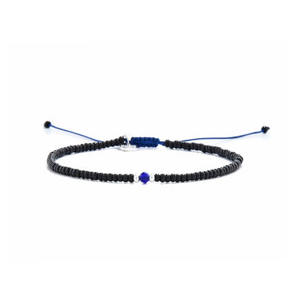 black and blue bead bracelet shown in full view with black seed beads with blue accent beads and adjustable cord