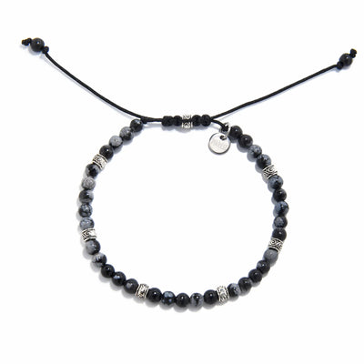 Adjustable black and silver bracelet with polished jasper beads and silver detailing, laid flat.