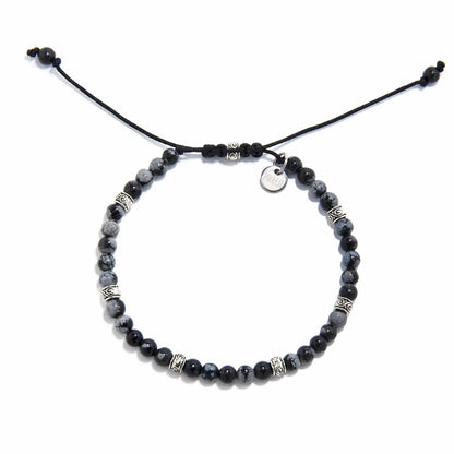 Adjustable black and silver bracelet with polished jasper beads and silver detailing, laid flat.