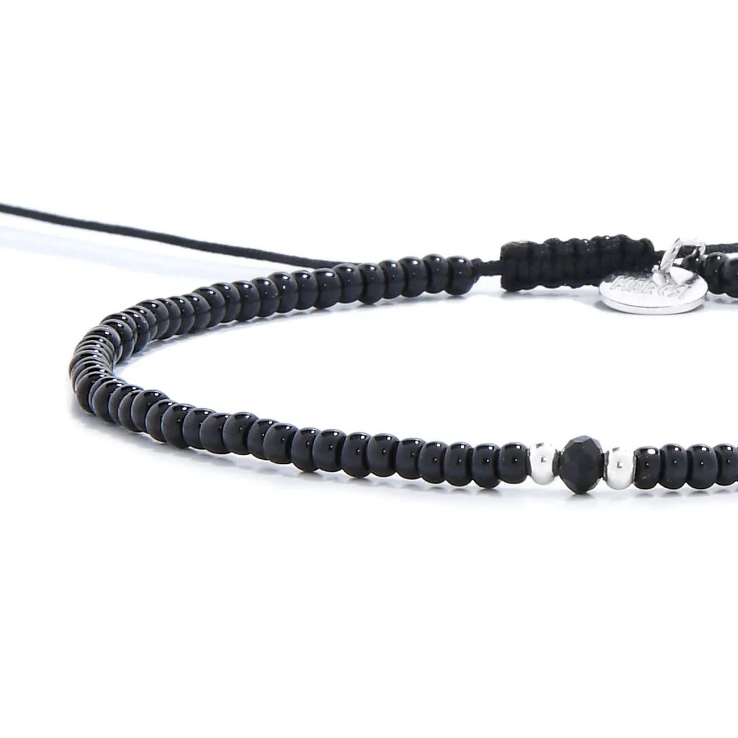 Close-up of black crystal bracelet for men showing black seed beads with dark faceted accents, silver charm, and cord closure