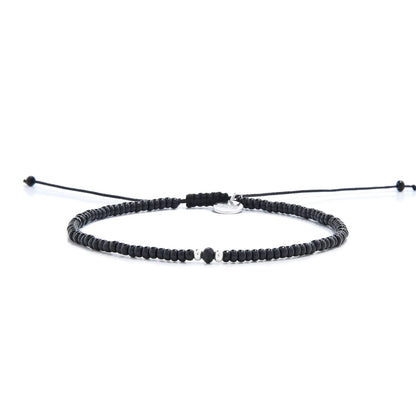 black crystal bracelet for men shown in full view with black seed beads with dark faceted accents and adjustable cord