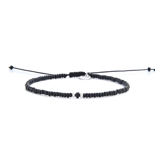 black crystal bracelet for men shown in full view with black seed beads with dark faceted accents and adjustable cord