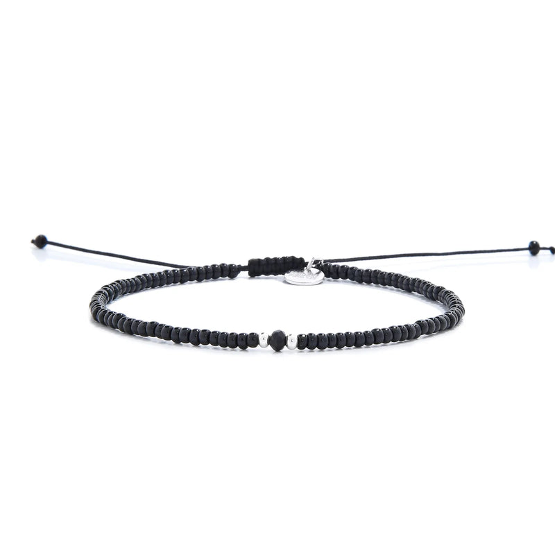 black crystal bracelet for men shown in full view with black seed beads with dark faceted accents and adjustable cord