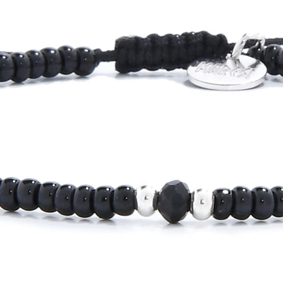 Detailed view of black crystal bracelet for men with black seed beads with dark faceted accents, seed bead texture, and cord knot