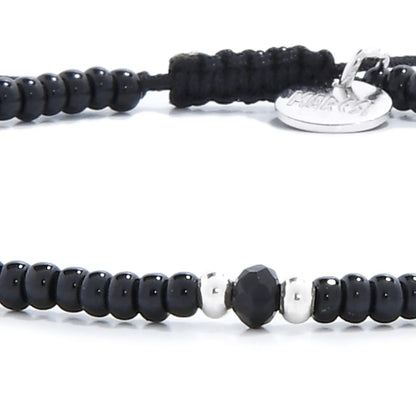 Detailed view of black crystal bracelet for men with black seed beads with dark faceted accents, seed bead texture, and cord knot
