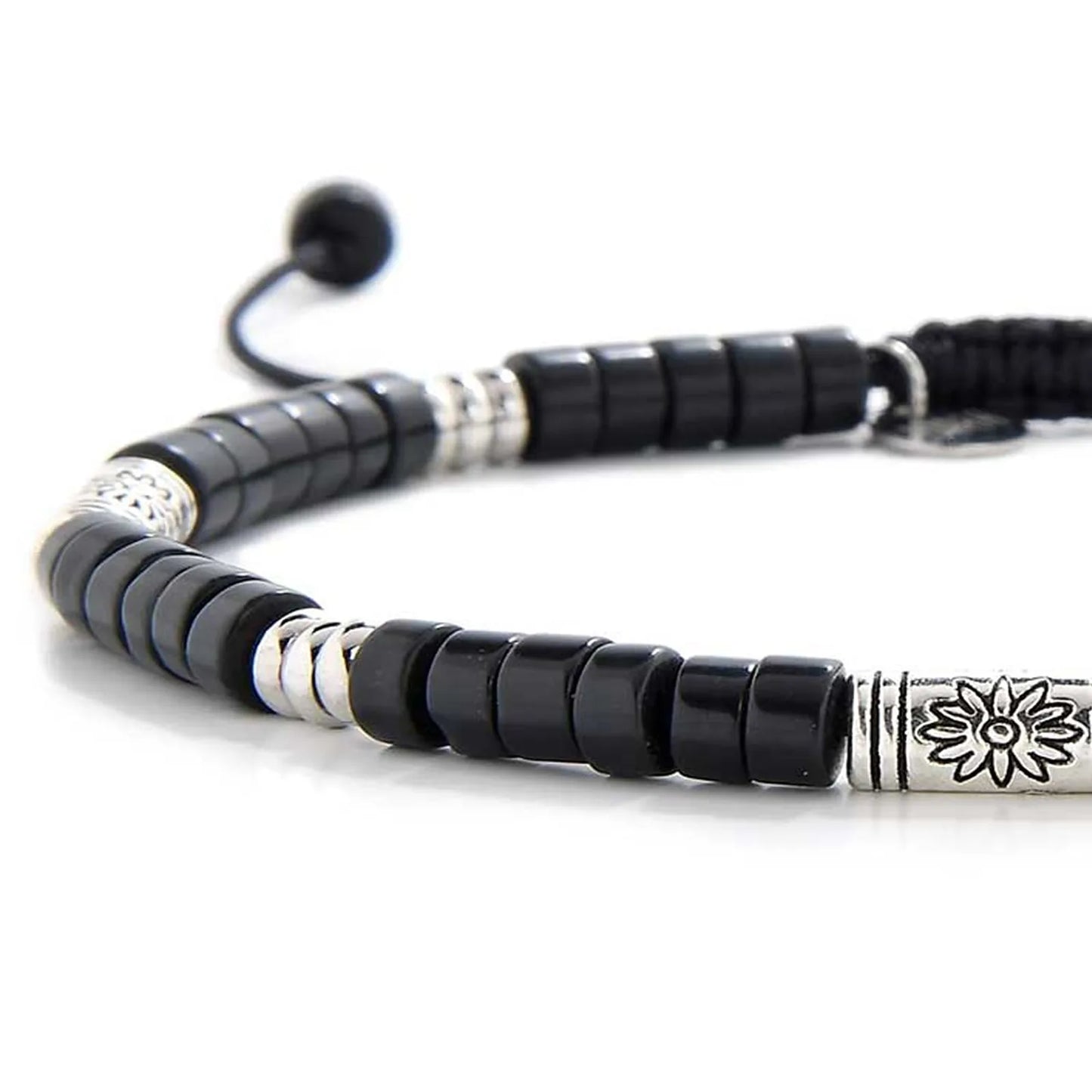 Detailed view of black shamballa bracelet with black clay beads with engraved silver spacers, Shamballa clay bead texture,
