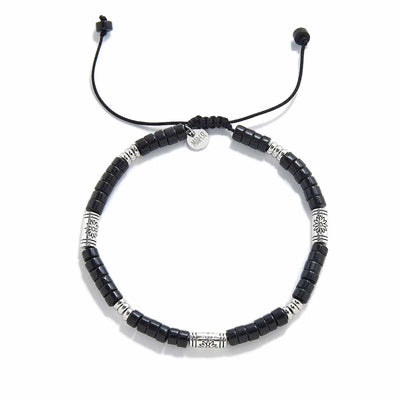 black shamballa bracelet shown from above with black clay beads with engraved silver spacers and round bracelet shape