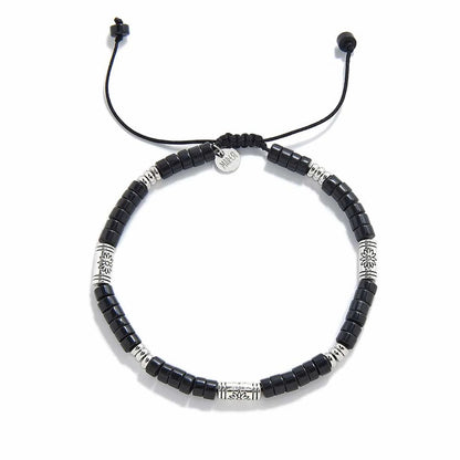 black shamballa bracelet shown from above with black clay beads with engraved silver spacers and round bracelet shape