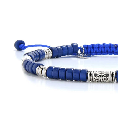 Close-up of Blue Beads showing blue clay beads with engraved silver spacers, silver charm, and cord closure