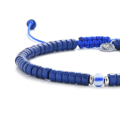 Close-up of Blue Gemstone Jewelry showing blue clay beads with blue accent bead, silver charm, and cord closure