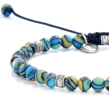 Bracelet Malachite close-up with polished blue beads, silver charm, navy cord, and bracelet texture