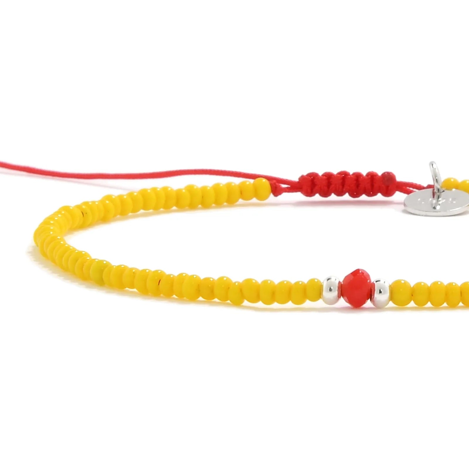 Close-up of Bracelet with Glass Beads showing yellow seed beads with red glass accents, silver charm, and cord closure